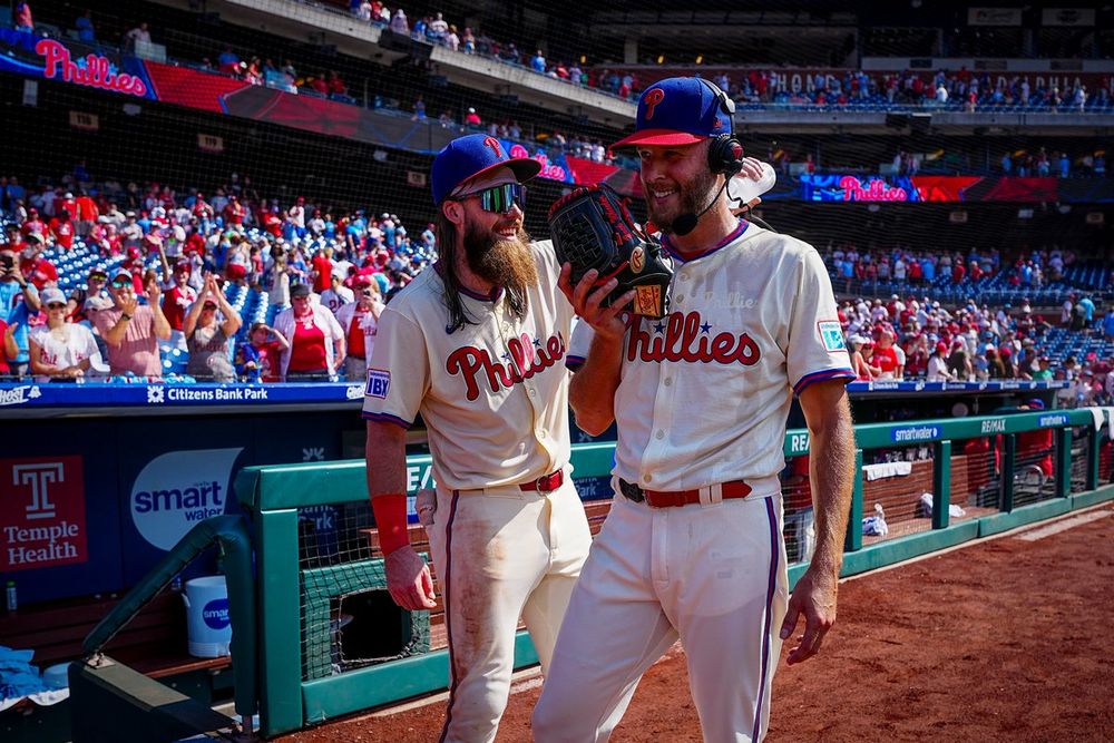 Brandon Marsh pours water on Zack Wheeler after his complete game. They are wearing the cream Phillies unis