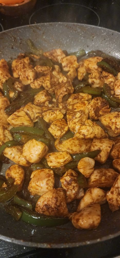 Picture of diced chicken and bell peppers cooking in a pan