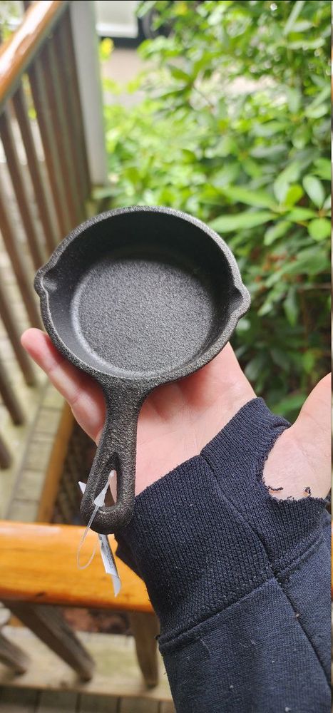 Picture of a palm sized cast iron skillet. Big enough to cook a single egg.