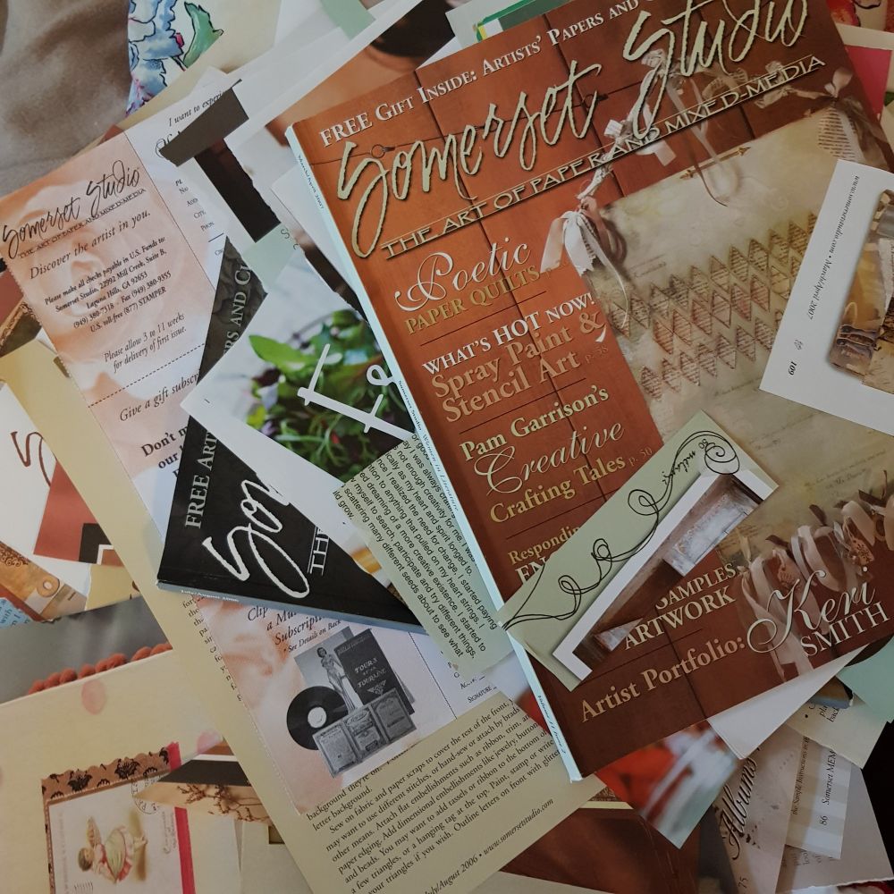 Somerset Studio magazines from early 2002 to 2006 in a jumbled pile with torn pages. #artjournaling #collagefodder