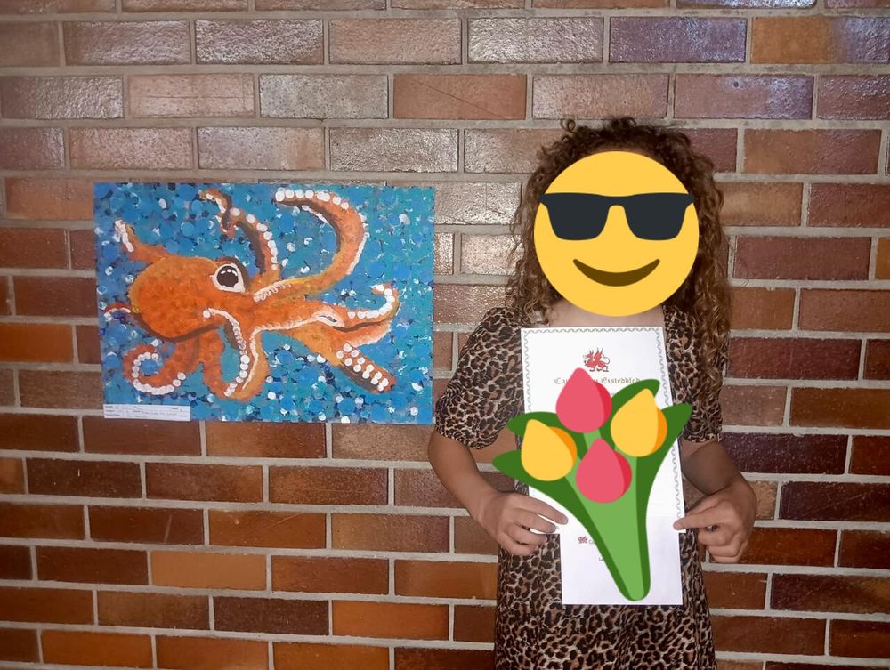 My niece next to her octopus artwork. Not giving AI scrapers any more info than that, sorry friends. 🩷