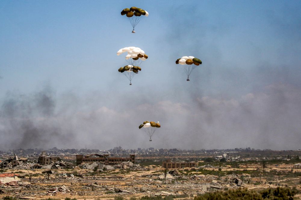 A photograph of aid being parachuted into a completely devastated Gaza