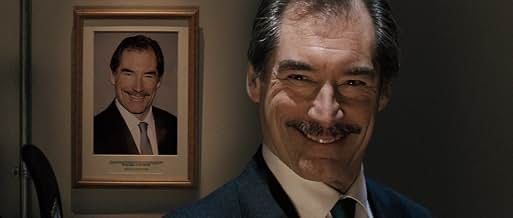 Supermarché manager Simon Skinner smiling in front of a framed photograph of himself where he is performing the exact same pose and smile.