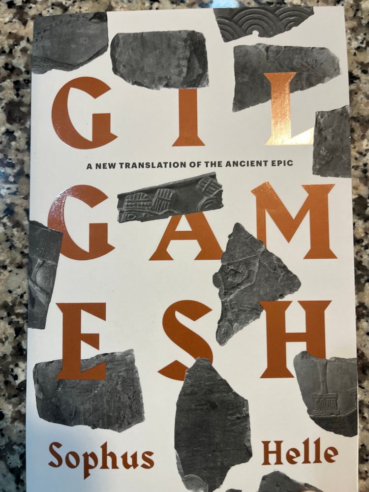 The front cover of Gilgamesh, translated by Sophus Helle, with bits of broken clay tablets scattered on it.