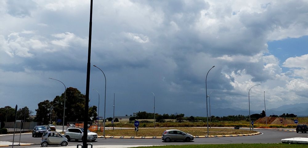 Grey clouds cover the sky and the landscape on the horizon is already covered from sight by a veil of rain. 