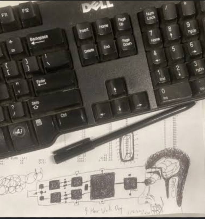 Foto de um teclado dell preto e uma caneta preta preta por cima de um papel com vários rabiscos e um desenho de um homem de perfil usando óculos escuros e com o cérebro exposto. Do óculos dele se projetam vários quadrados e abaixo do desenho estão os dizeres "9 hour work day"