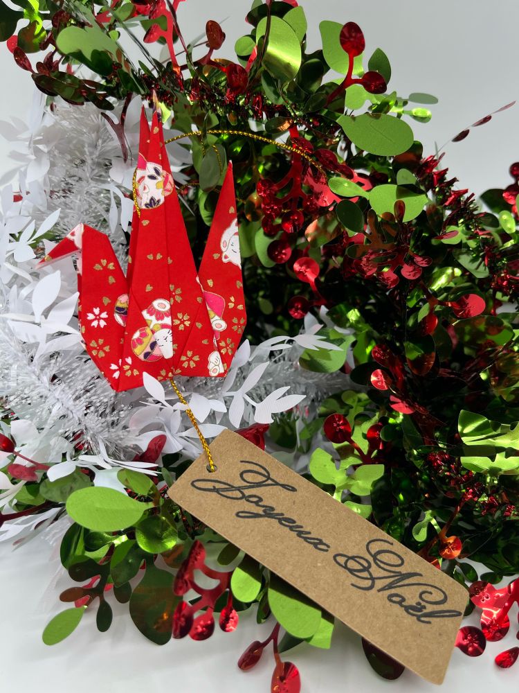 Grue en papier japonais avec un petit mot en dessous: joyeux Noël 