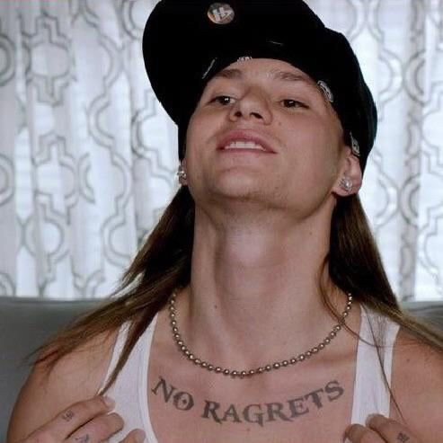 Guy showing misspelled tattoo “No Ragrets”