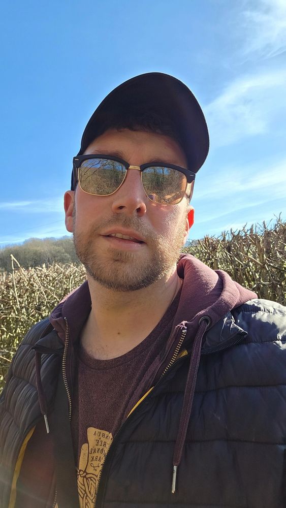 Selfie of a man in a cap and sunglasses outdoors 