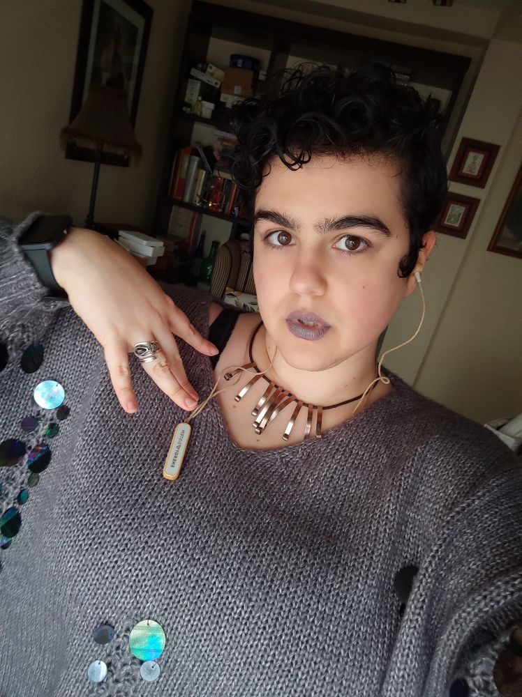 Photo of my dork ass trying to strike a "cunty" pose and showcase my humble fit of a cold grey sweater with big holo sequins and matching lips
