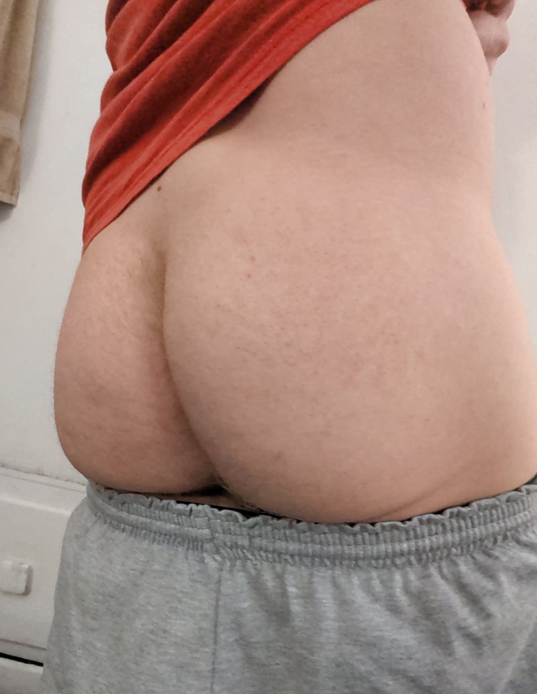 Me, standing up and showing my butt. My shorts are pulled down just below the cheeks and my shirt is pulled up