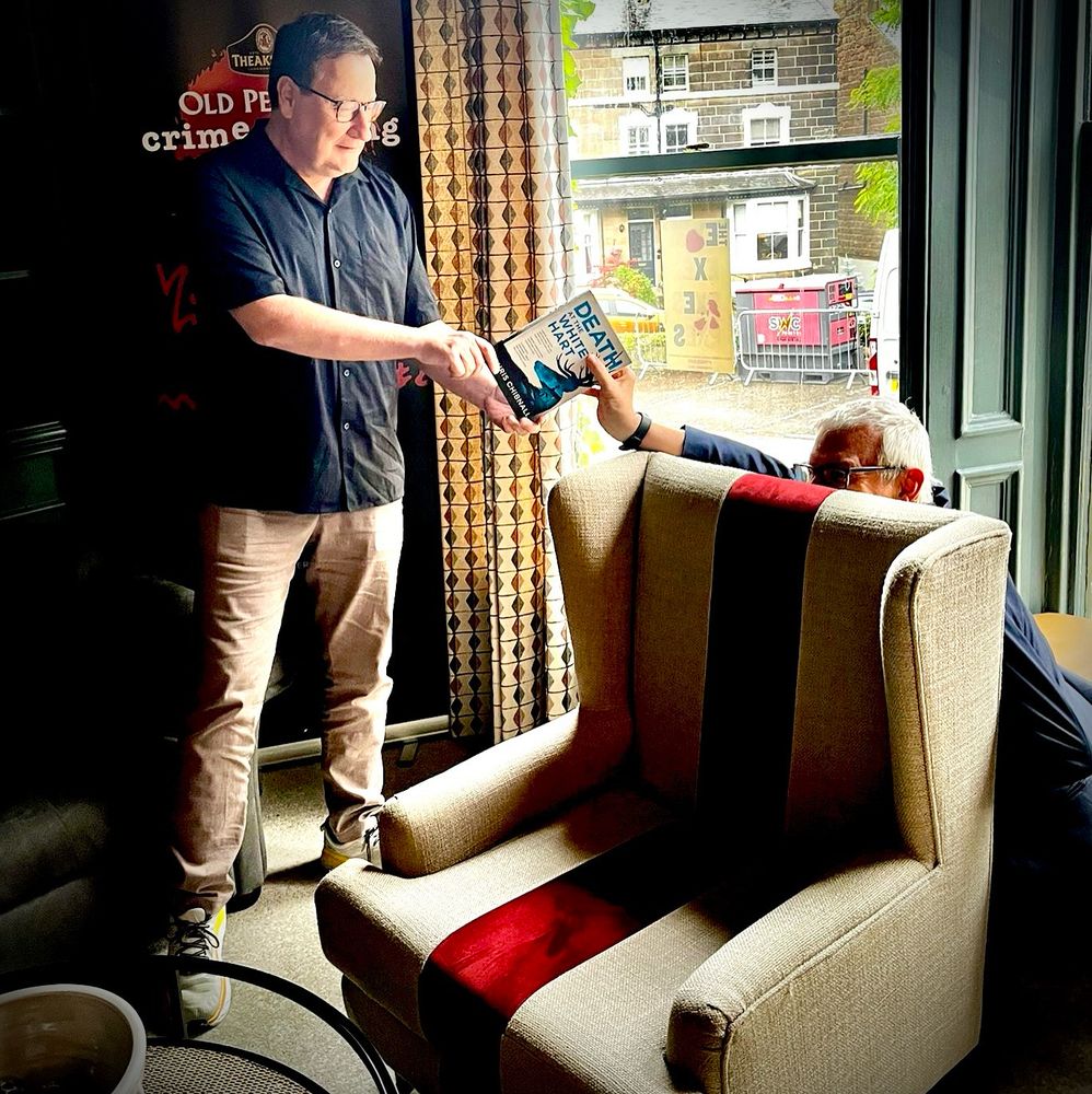 Jeremy Vine, in the library at the Old Swan Hotel in Harrogate, pretending to pinch a copy of Death at the White Hart from the author. It was Jeremy’s idea, who wouldn’t go along with it. 