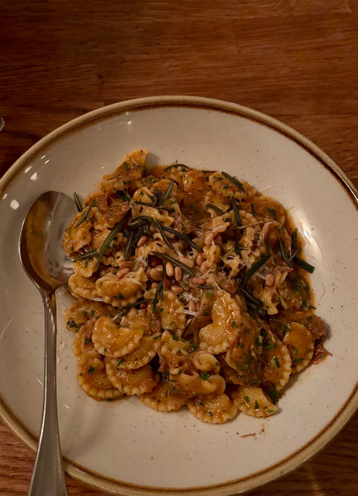 A plate of pasta in a bowl with a spoon 