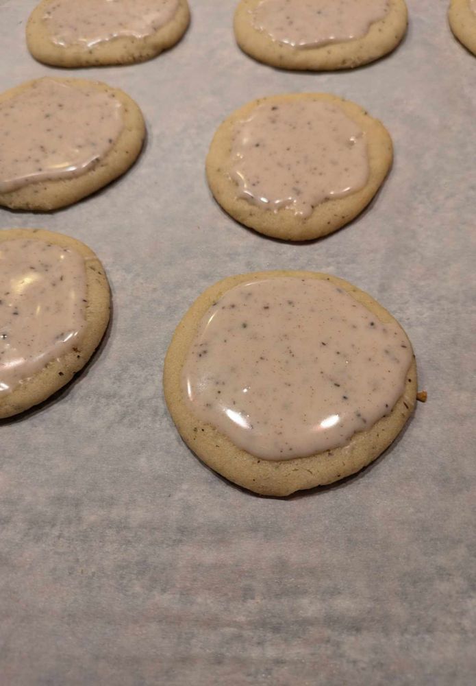 Taylor Swift chai sugar cookies iced on parchment paper.