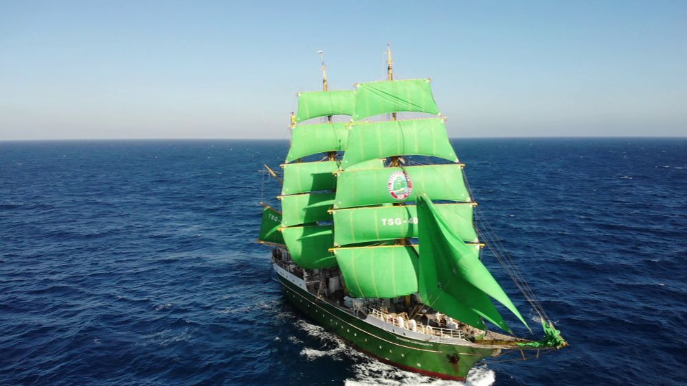 Die Alexander von Humboldt 2 mit ihren Markenzeichen grünen Segeln. Blick von oben auf das Schiff, um sie herum nur das tiefe blaue Meer