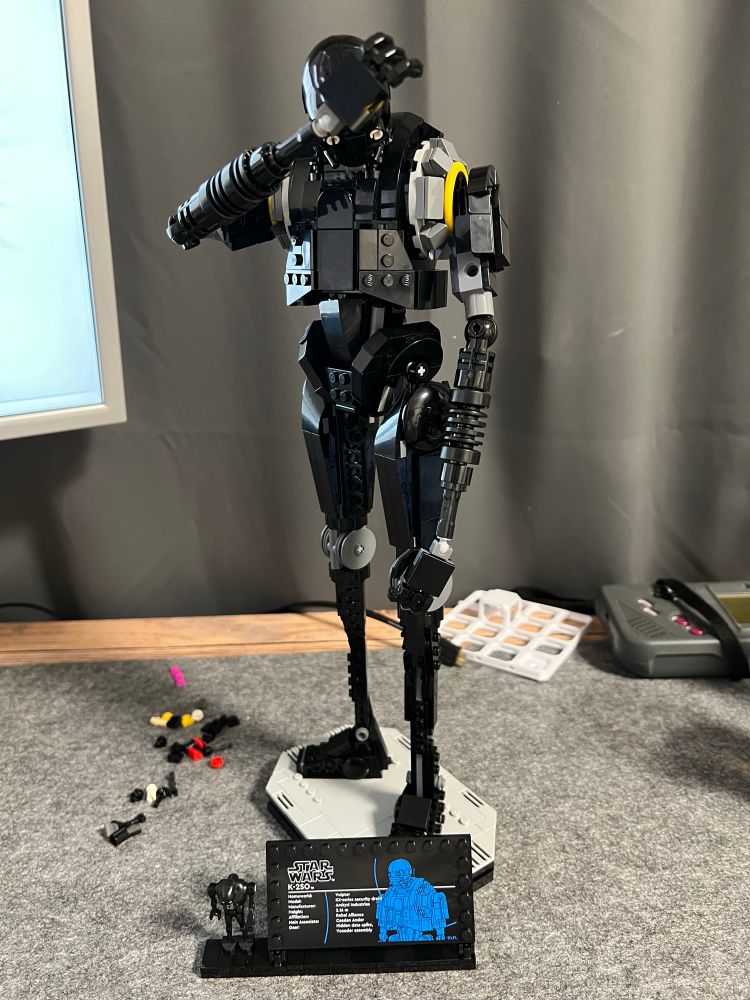 Brick build (Lego) K-2SO from Star Wars front/left view his head is bowed down and his right hand over his forehead 
