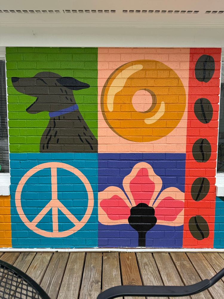 A mural with a dog, a donut, a peace sign, and a flower.