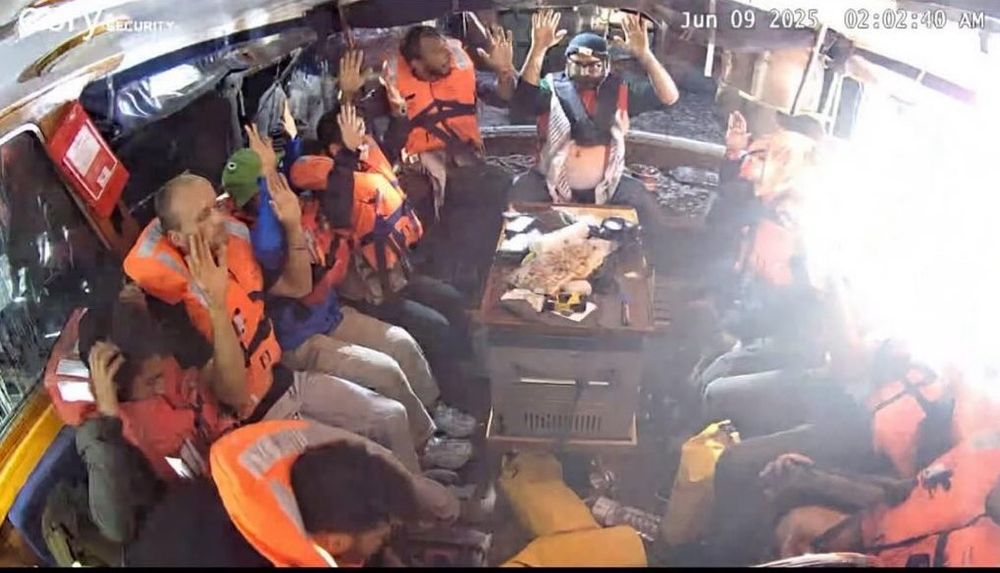 Photo of the crew holding their hands up after being intercepted and attacked by the genocidal Israeli navy — and kidnapped 