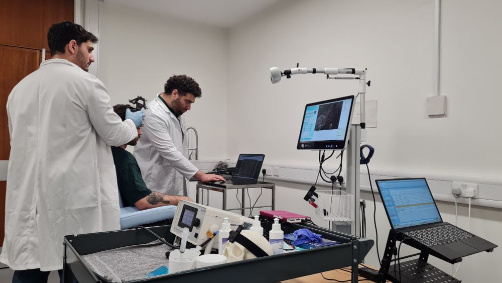 Photo of two researchers scanning patients brain.