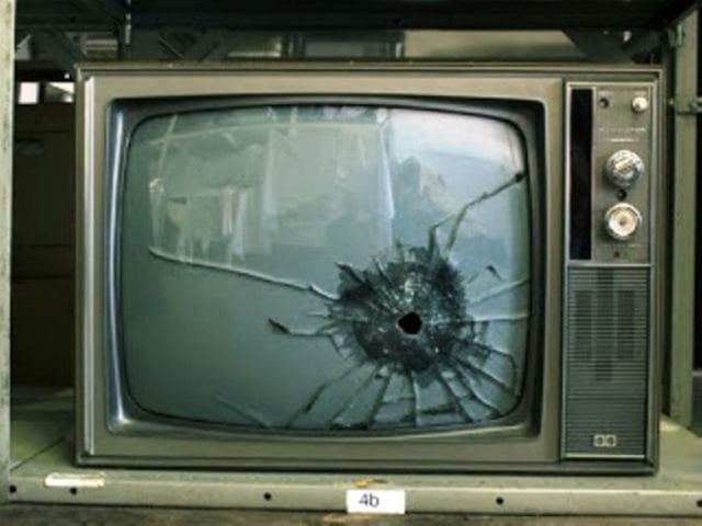 An old fashioned TV set with a hole in the screen.