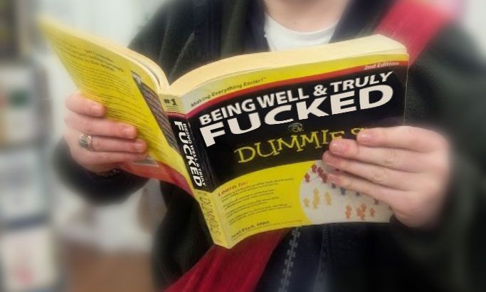 A person holding a "______ for Dummies" style of book with its distinctive yellow cover. The title reads "Being Well & Truly Fucked for Dummies."