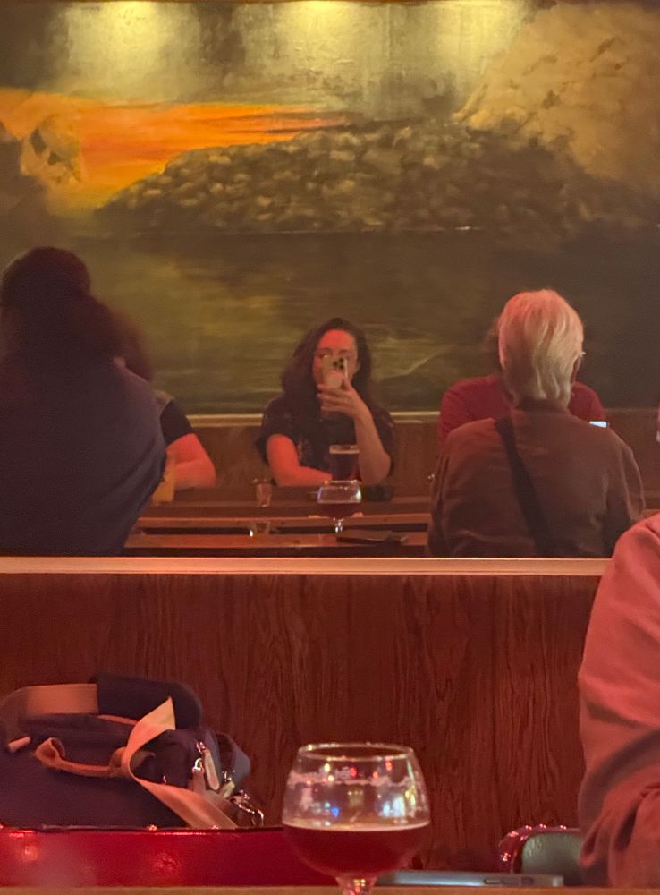 A mirror selfie across my favorite Philadelphia dive bar, a mural behind me.