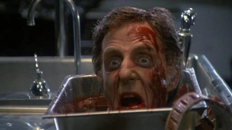 Cena do filme Re-Animator com uma cabeça decepada ressuscitada em cima de uma bandeja médica
