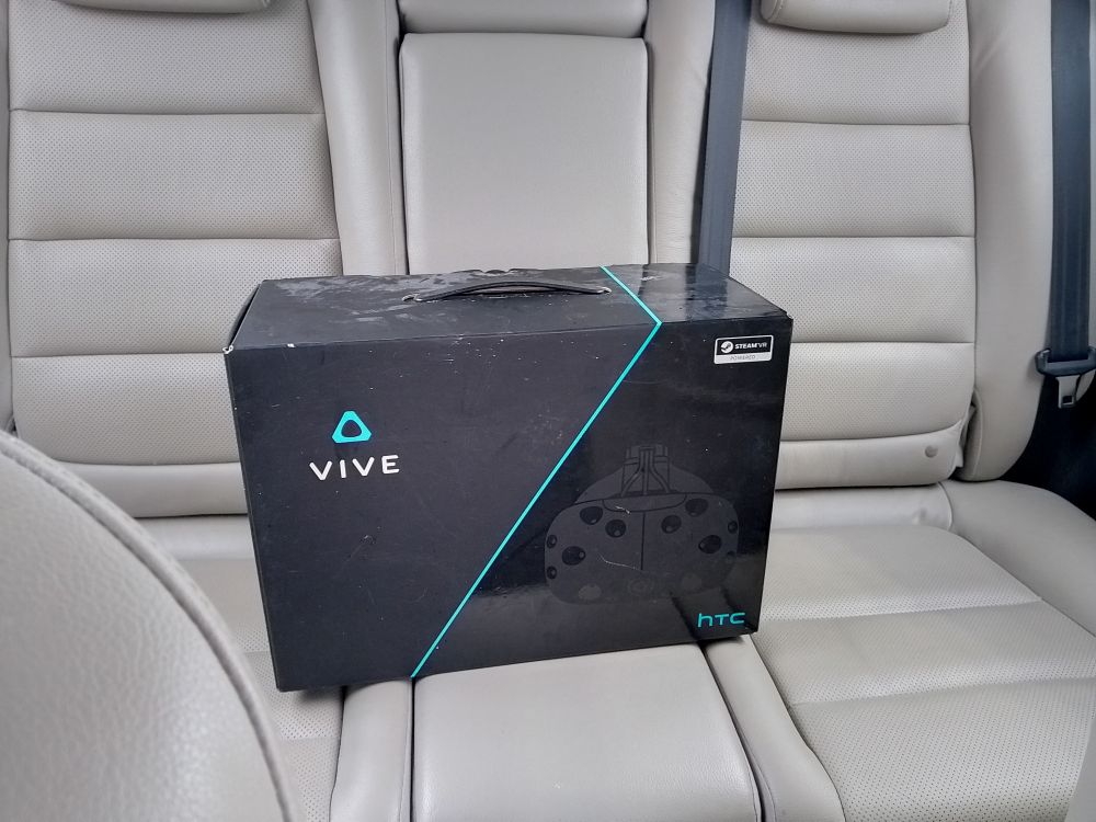 Box containing a VR headset, HTC Vive, sitting on the backseat of my car