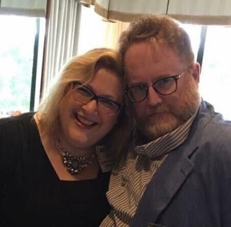 Beautiful woman stands near a bearded red headed fellow 