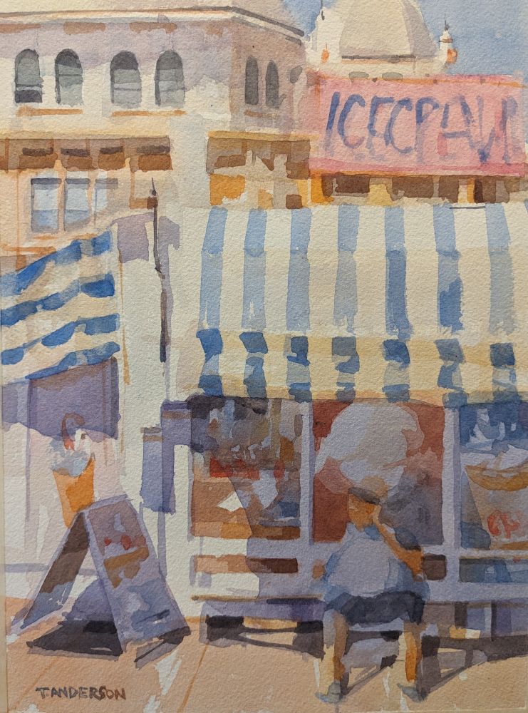 Watercolor painting of the side of a small ice cream stand in front of the Kurhaus in Scheveningen, The Hague. A large cream and royal-blue striped canopy extends from a small ice cream stand with the brick and domed architecture of the Kurhaus in the background. A person, in shadow sits on a white bench, under the canopy and in front of billboard advertisements for ice creams and shakes. A sandwich board, in shadow, displays other items on the left. A pink sign, covered in sunlight rests atop the stand with candy-blue lettering.