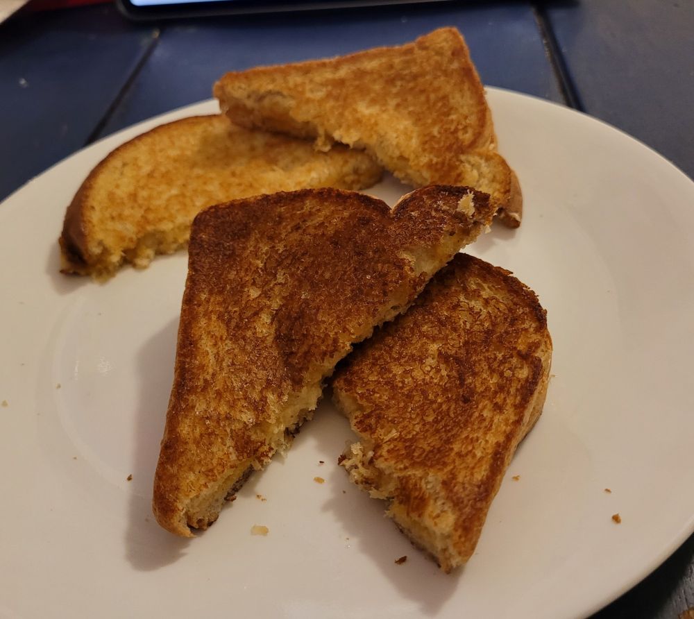 2 grilled cheese sandwiches sitting on a white plate