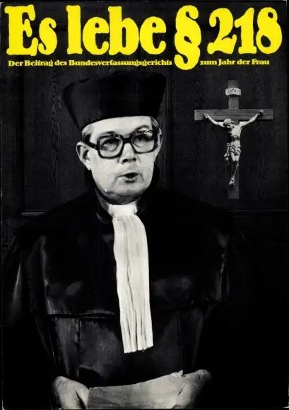 Ernst Benda in der Robe eines  Bundesrichters, hinter ihm ein gekreuzigter Christus. Text in 70er Jahre Typo: Es leben §218 / Ein Beitrag des Bundesverfassungsgerichts um Jahr der Frau. 