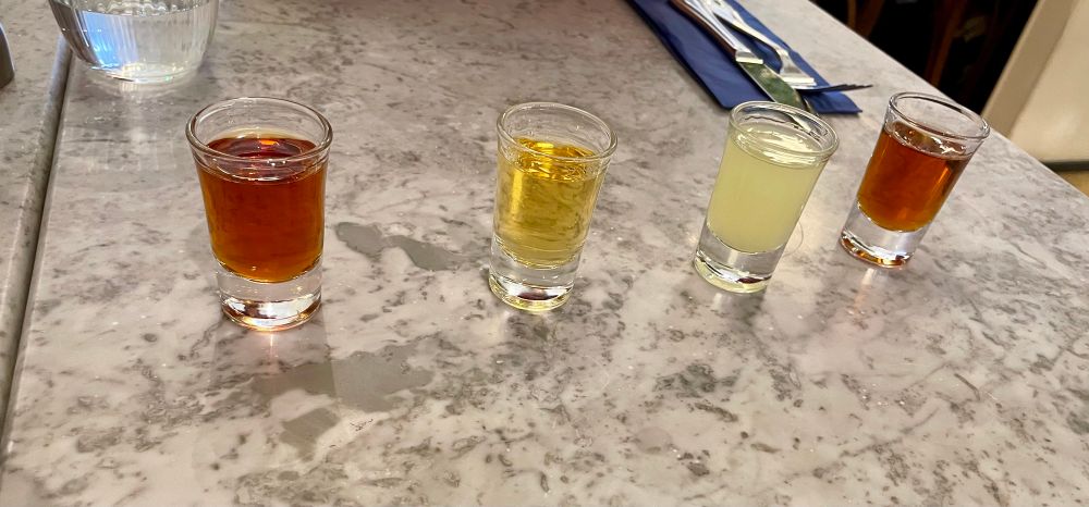 A row of amaros in shot glasses on a table 