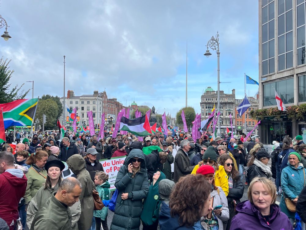 The crowd coming over O’Connell Bridge. Palestinian and INTO union flags.