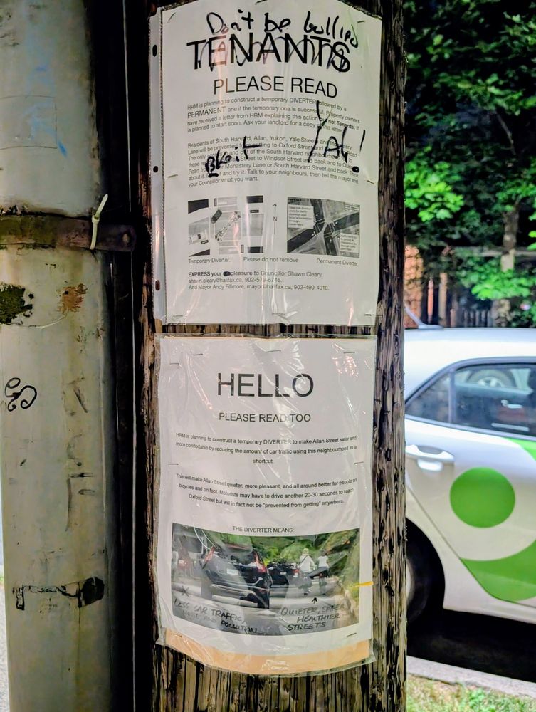 A photo of two posters on a telephone pole, one in opposition to a proposed modal filter on Allan Street in Halifax, the other in favour. The one in favour highlights the benefits of the diverter, namely less car traffic, noise, and pollution, and quieter, safer, healthier streets. The one in opposition talks about the inconvenience to drivers.