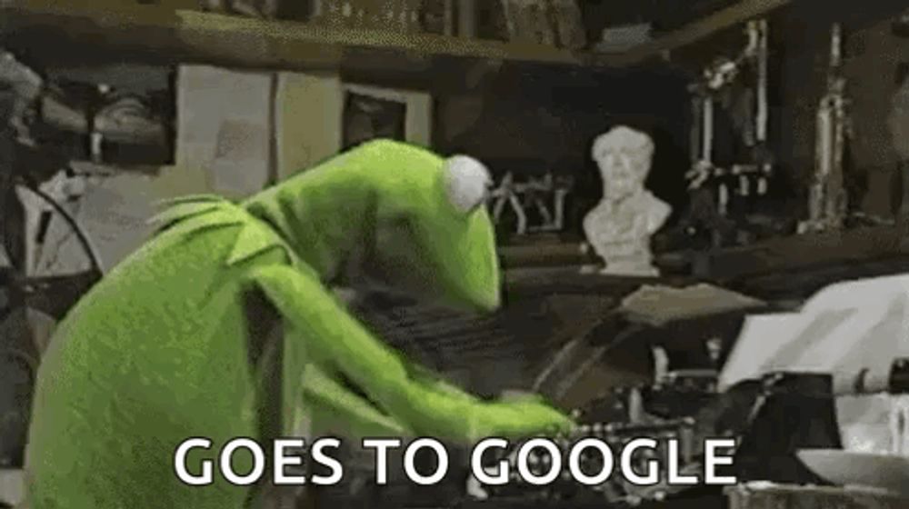 kermit the frog is typing on a typewriter in a dark room .