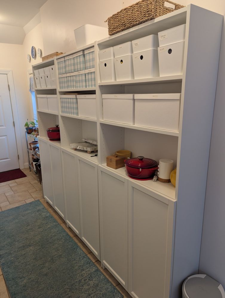 IKEA Billy bookcase with Oxberg doors, Kuggis glossy white storage container with lid and Tjene paper storage boxes.