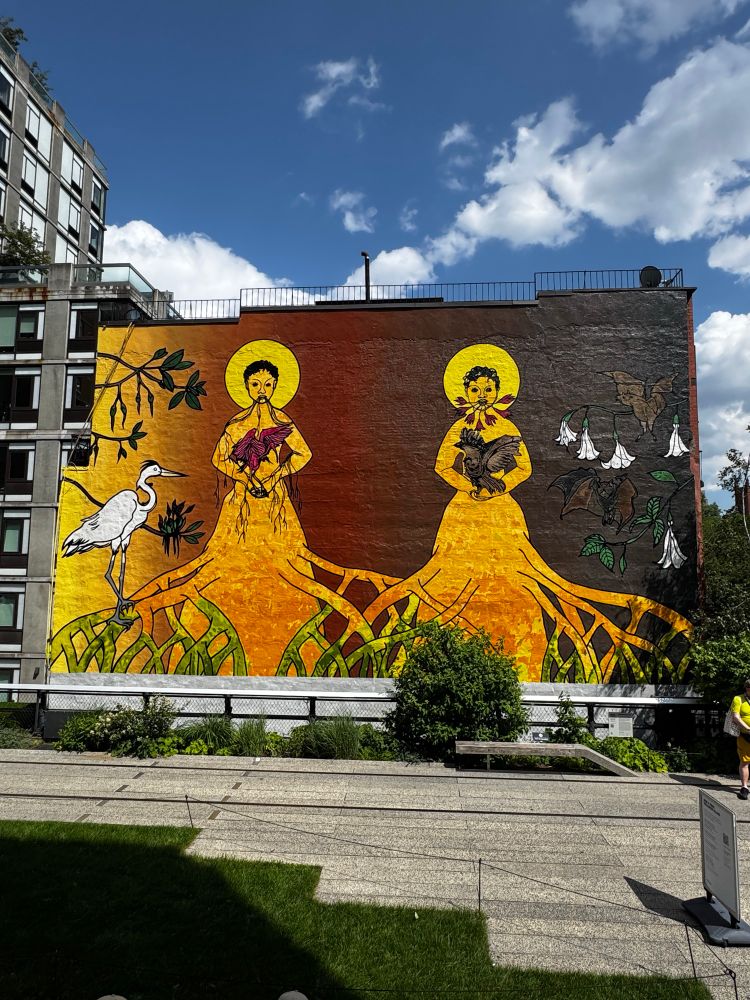 Mural on the High Line park with two women in yellow with roots and a stork 