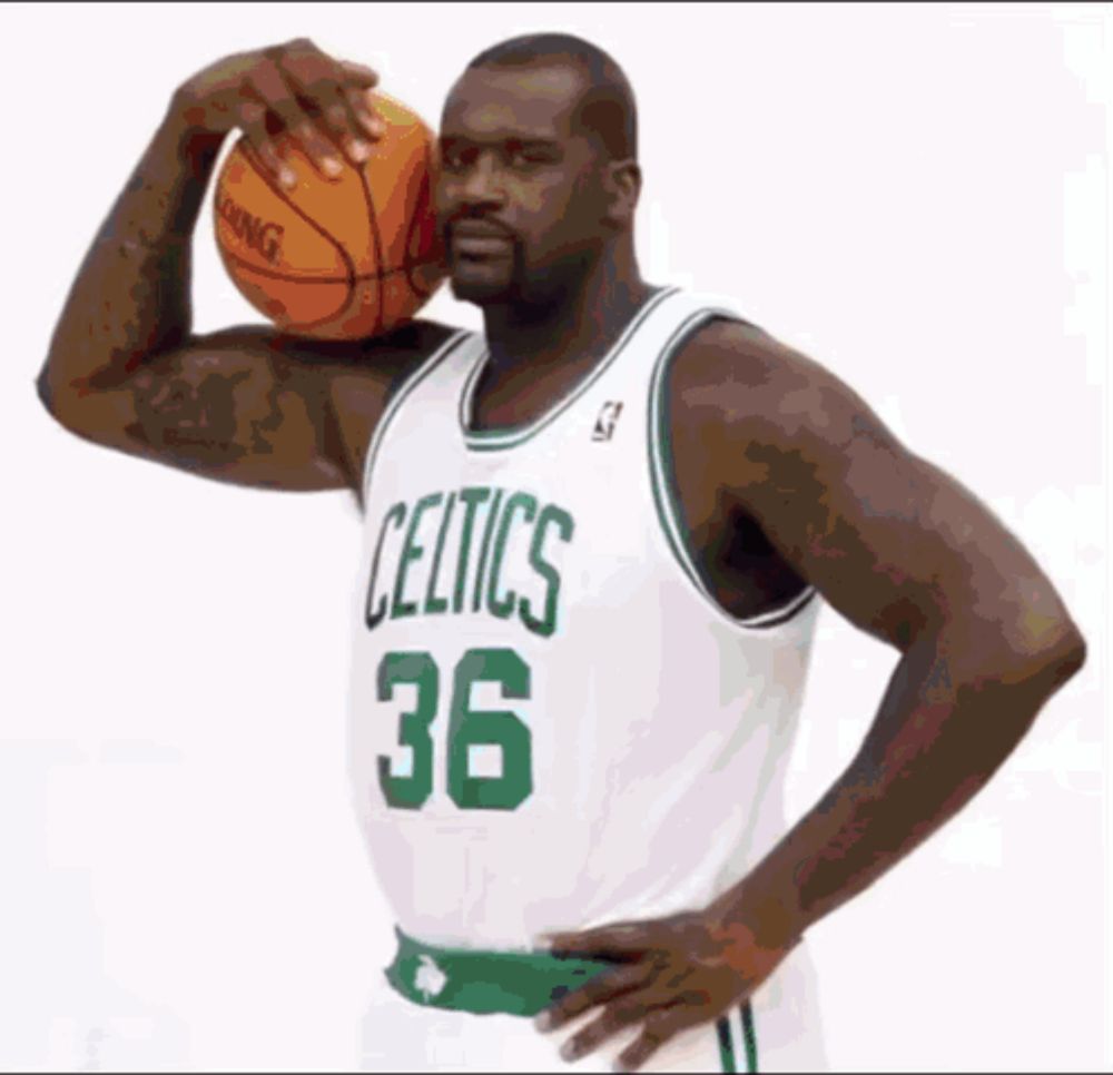 a celtics player holding a basketball over his head