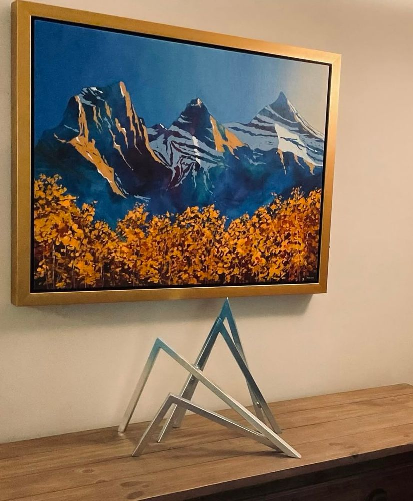 An abstract metal sculpture representing a snow capped mountain range.