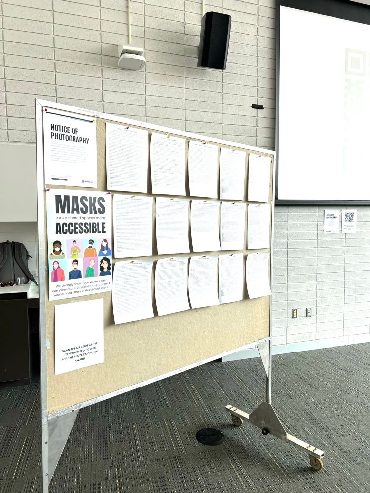 A poster board with papers pinned to it (anonymized student reflections), a notice of photography, and a reminder for voting for a people’s choice award.

A sign also says Masks make shared spaces more accessible. We strongly encourage you to wear a complimentary respirator mask to protect yourself and others in this shared space.