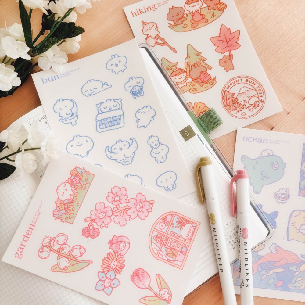 Image of sticker sheets laid out on a desk and journal.