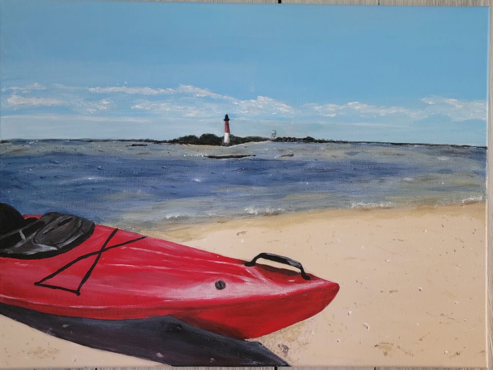 Kayak on the beach with lighthouse across the inlet