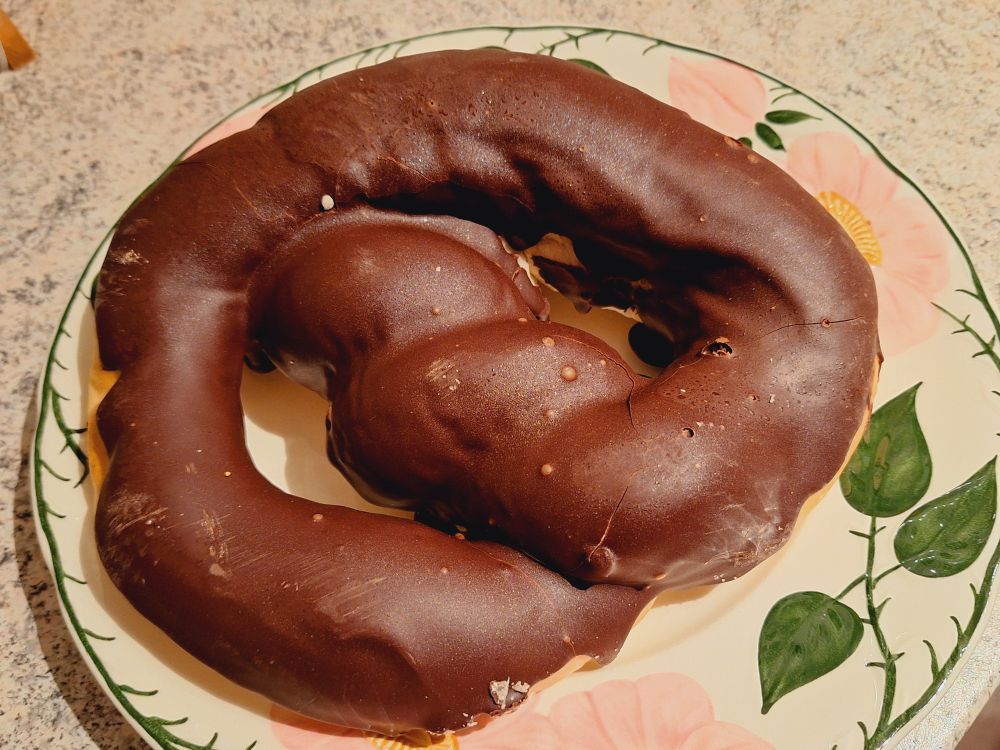 Eine riesige Brezel mit glänzender Schokohülle.
