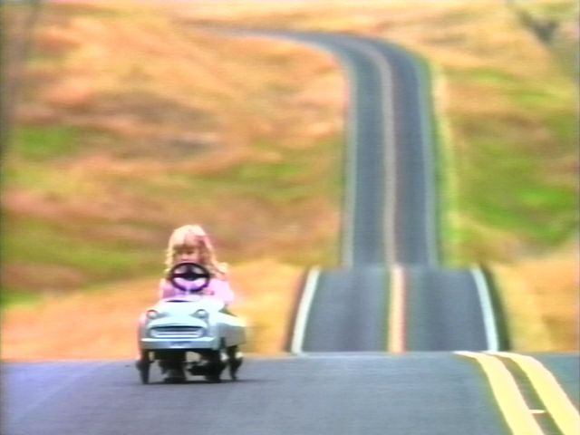 A '90s immunization PSA shows a little girl driving a toy Speedster on a hilly highway, all alone.