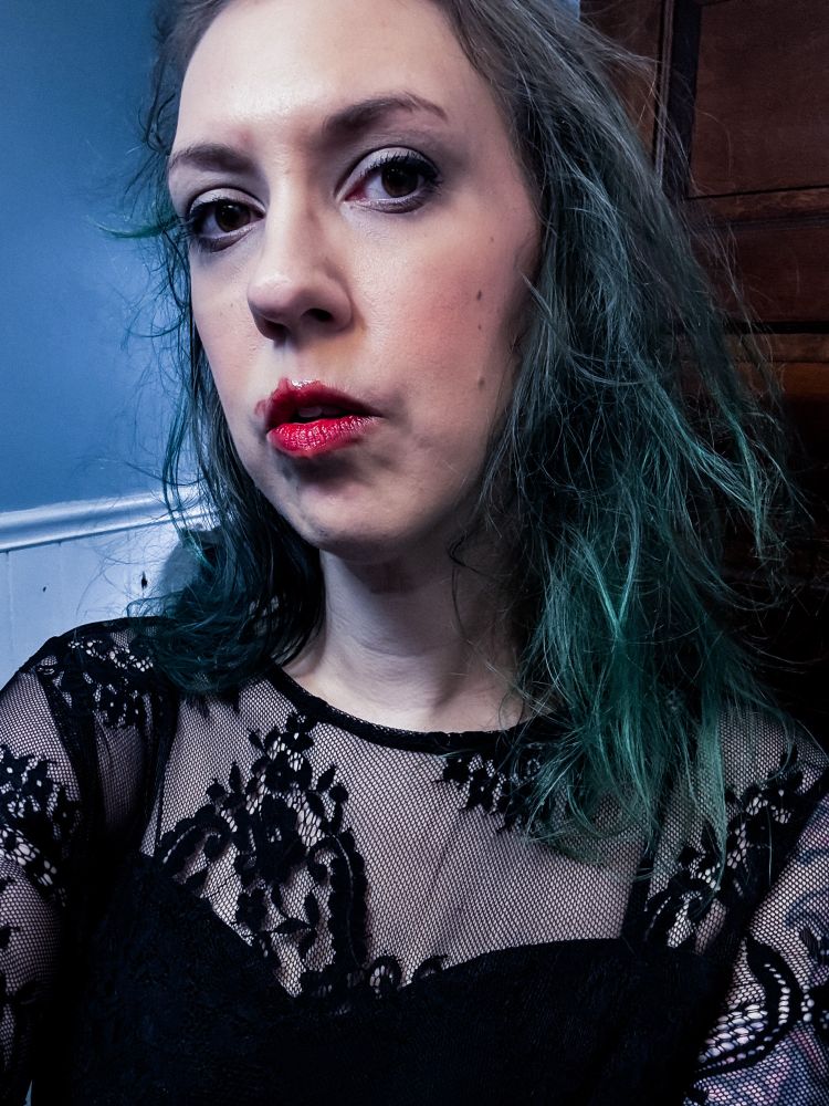 Woman wearing black goth Lacey dress with messy make up 