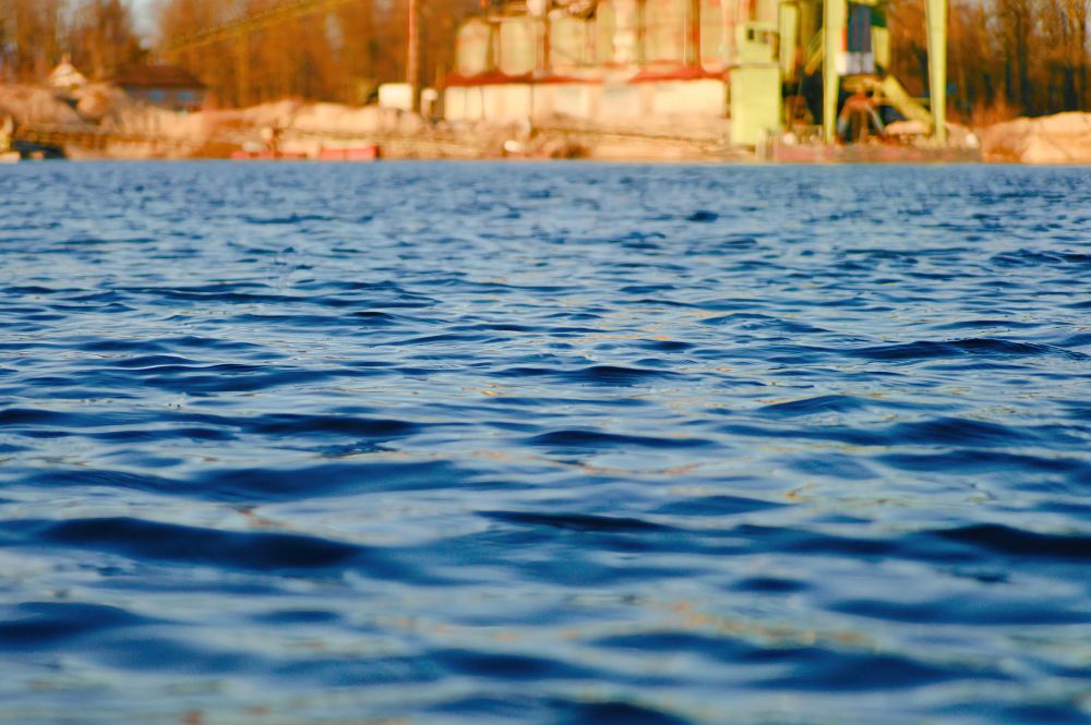 Blick über das Wasser eines Baggersees auf das Kieswerk