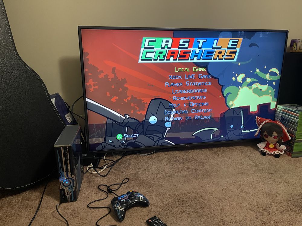 Castle Crashers running on an Xbox 360. A Reimu fumo is sitting beside the TV. 