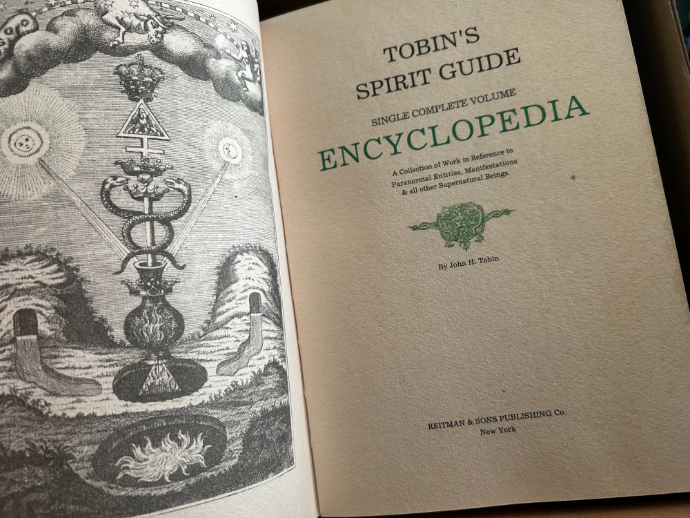 The inside front page, with a highly detailed illustration on the left hand page and the title with more written detail on the right hand one. Which reads Tobins Spirit Guide, single complete volume encyclopaedia,  a collection of works in reference to paranormal entities, manifestations and all other supernatural beings. 