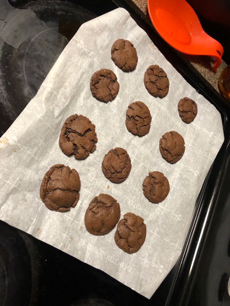 twelve chewy cookies cooling on a sheet of parchment paper